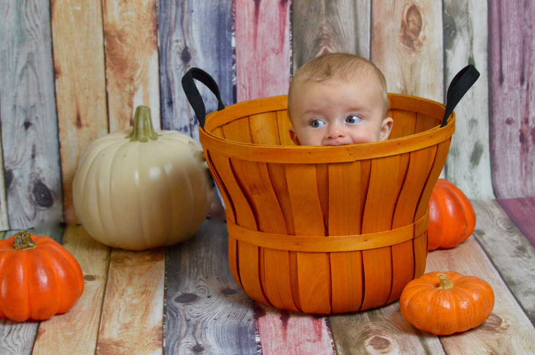 Picture of a little baby in a themed fall photography set in our photography studio